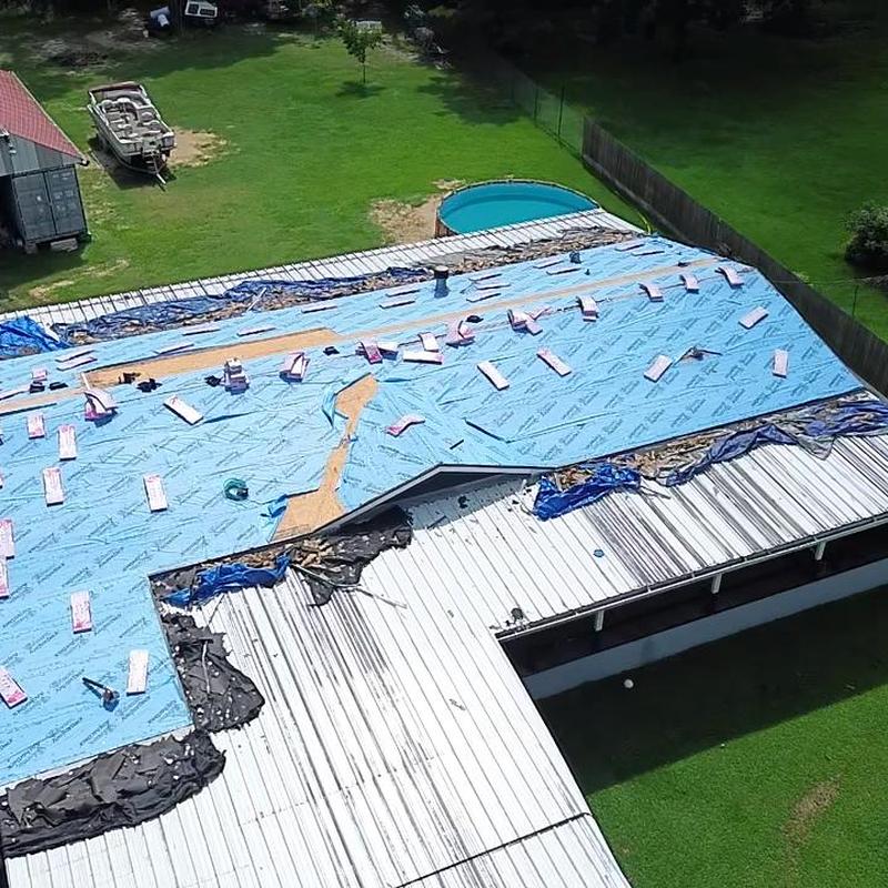 Residential roof underlayment installation with materials visible