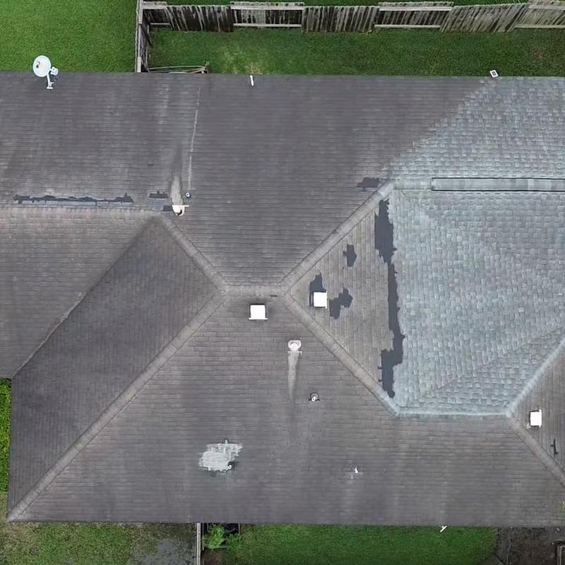 Asphalt shingle roof with damage and repairs visible