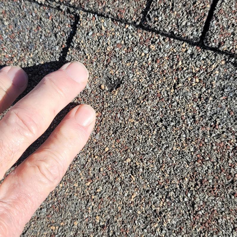 Asphalt roof shingles with hail damage close-up