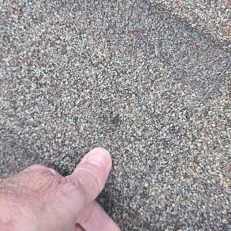 Asphalt shingle close-up showing hail damage granules