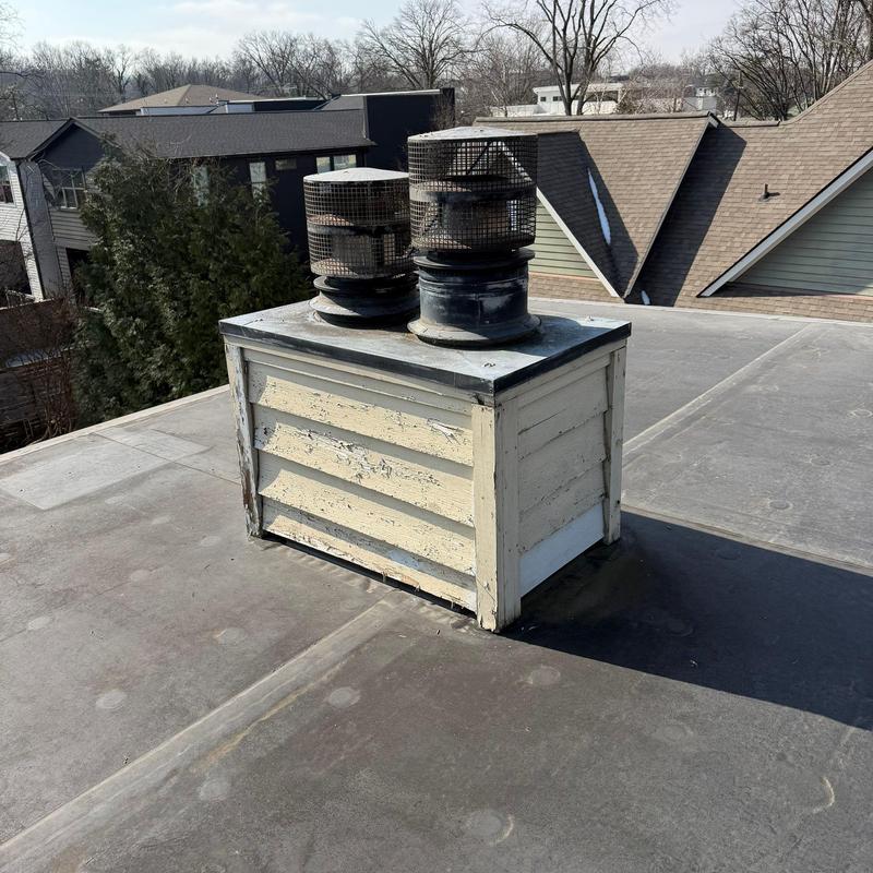 Roof vent exhaust pipes on flat roof with peeling paint
