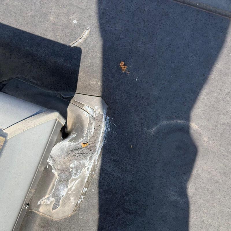 Roof flashing with hail damage and sealant buildup
