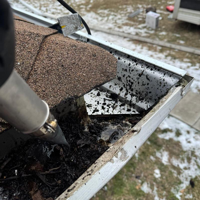Gutter cleaning debris removal on residential roof edge