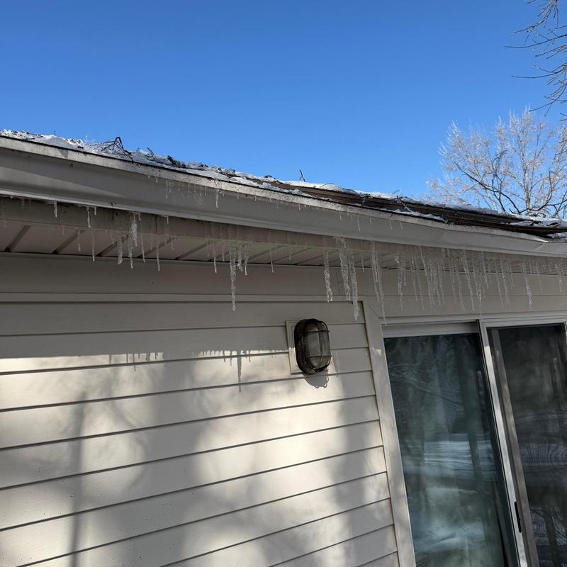 Roof edge with icicles hanging from gutters