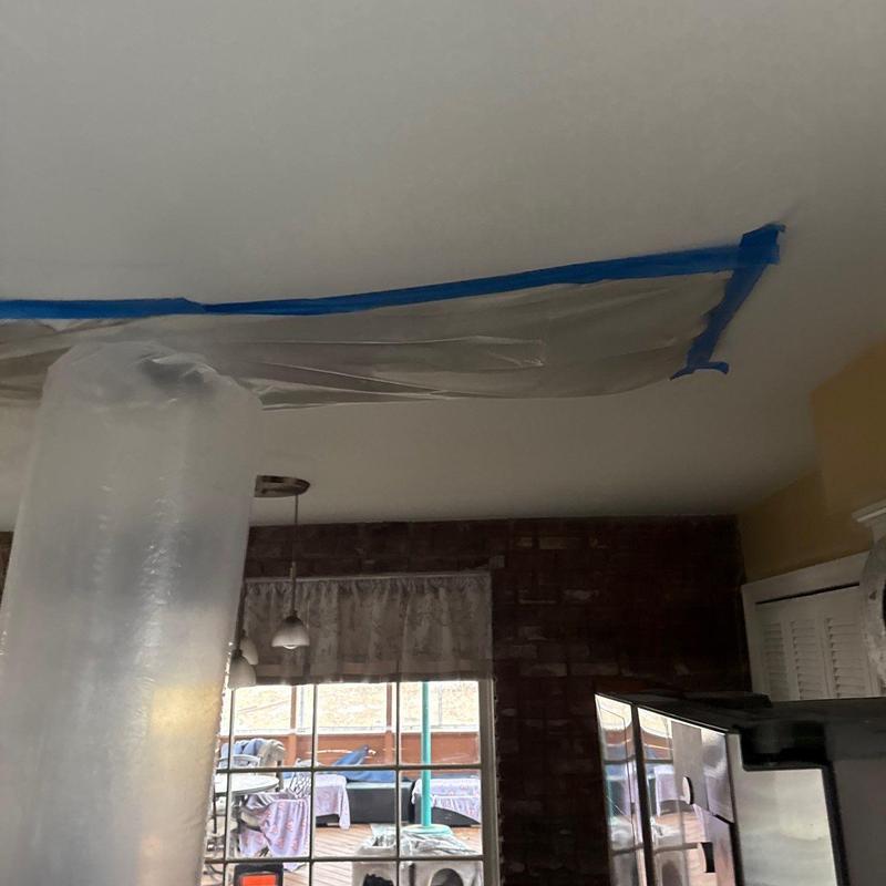 Ceiling water damage containment setup with plastic sheeting
