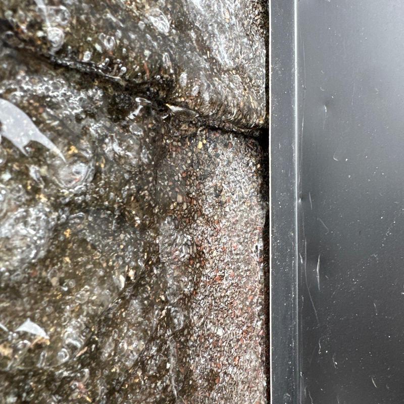 Roof shingle hail damage near metal flashing close-up