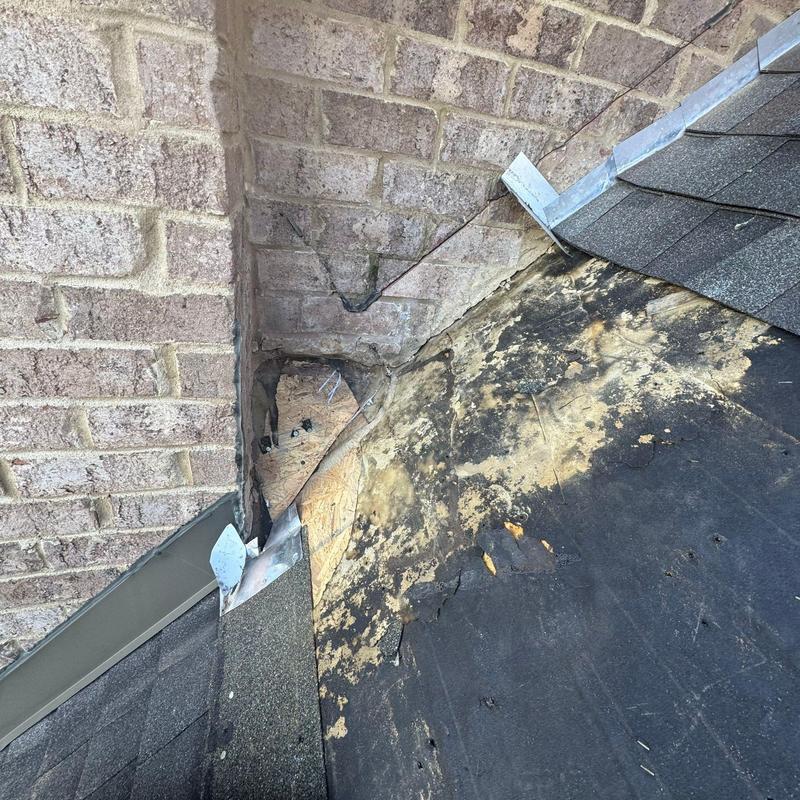 Roof flashing and shingle damage with exposed plywood
