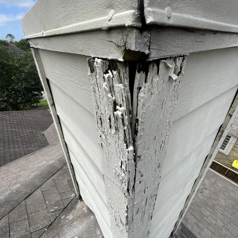 Chimney wood rot and siding damage on roof corner