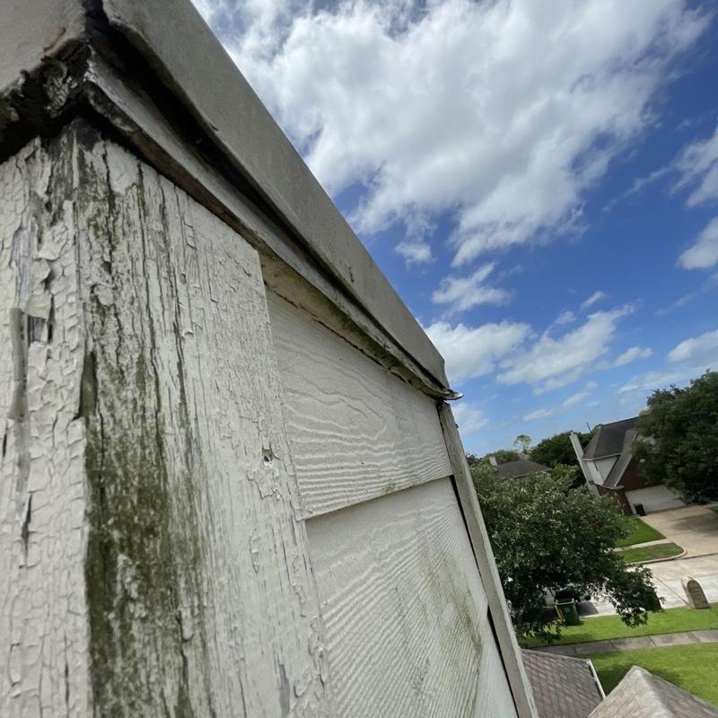 Chimney siding damage with wood rot and peeling paint
