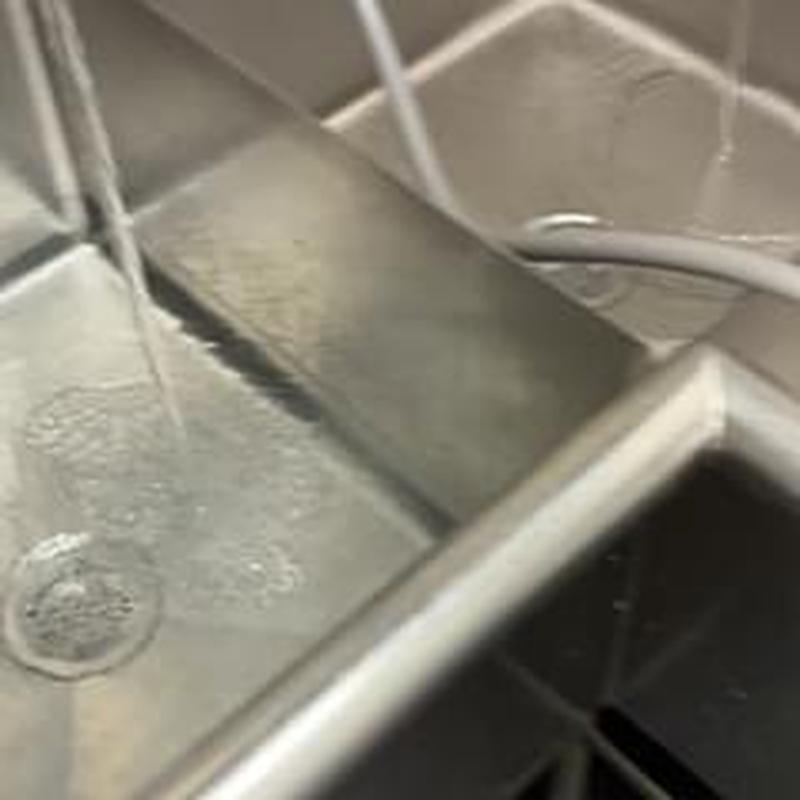 Floor sink drain with water flowing and hoses