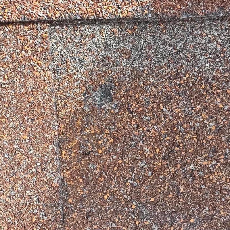 Roof shingle granules with hail damage spot