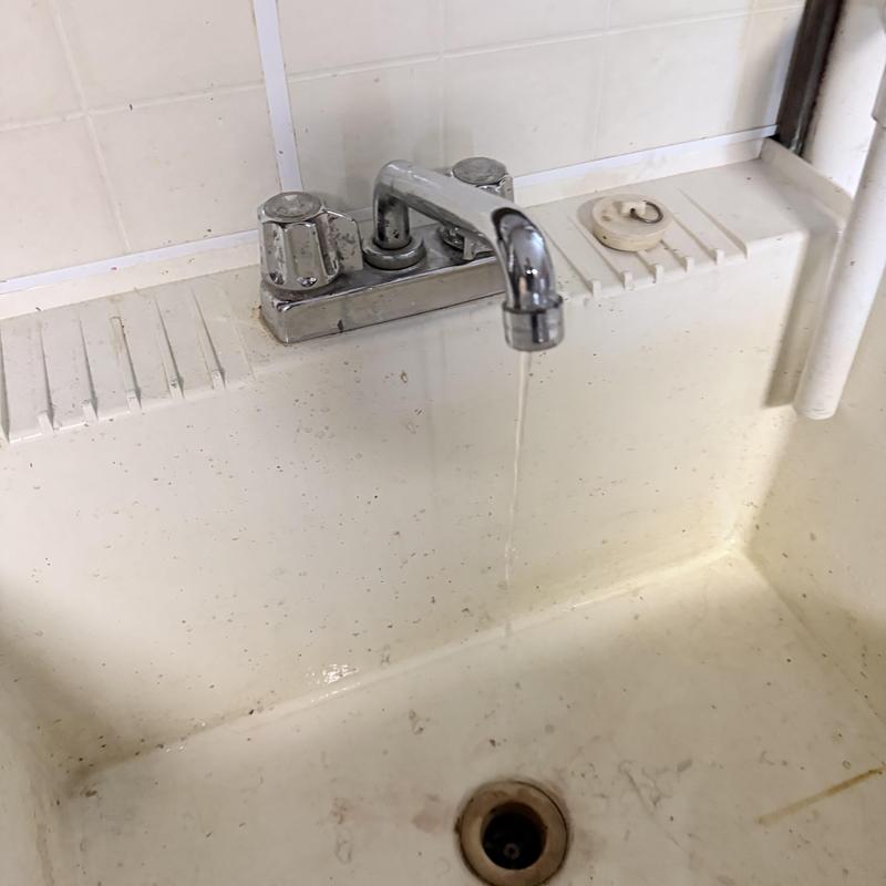 Slop sink faucet with water running in basement Slop sink faucet with water running in basement