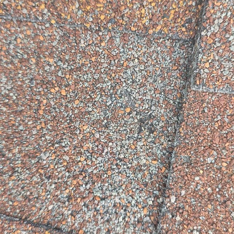 Asphalt shingle granule loss from hail damage close-up