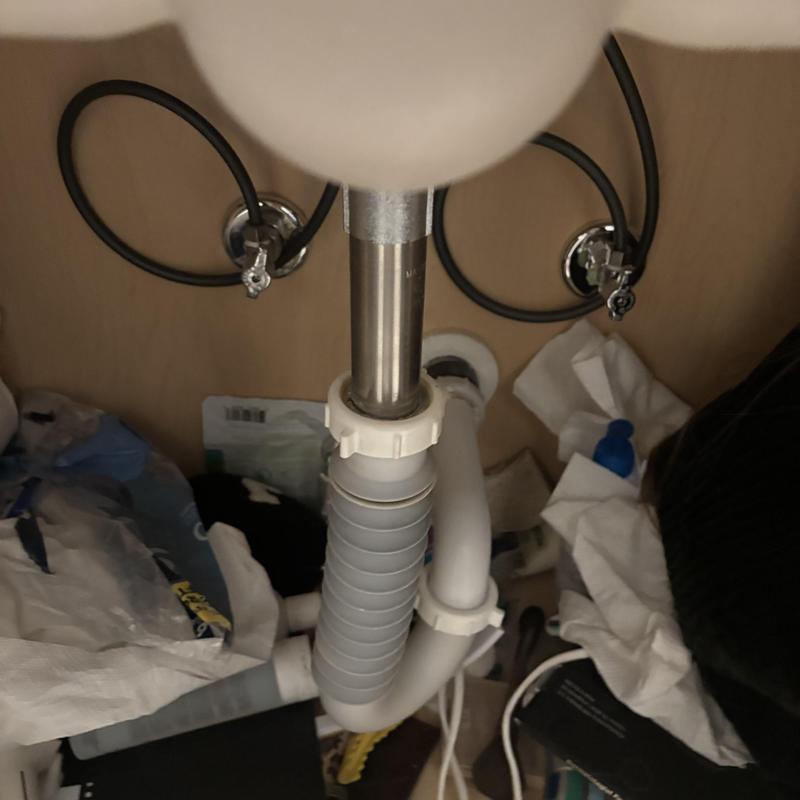 Vanity sink drain pipe cleaning under cabinet