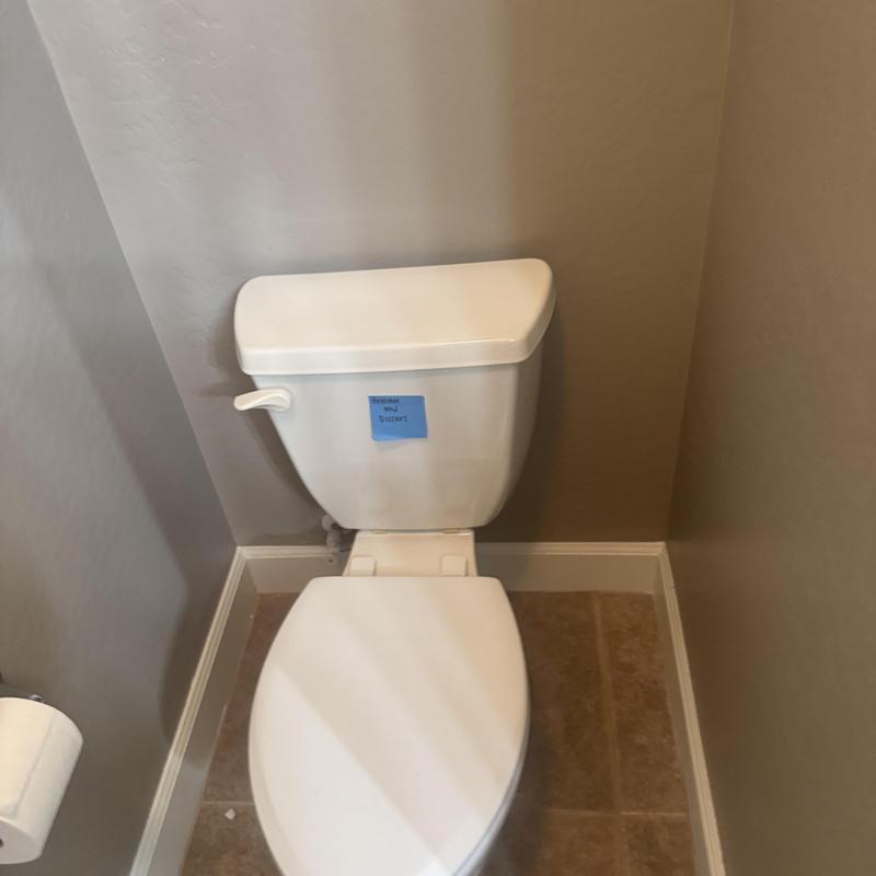 Toilet with removal notice in bathroom corner