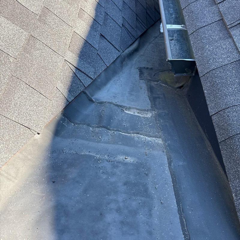 Flat roof membrane with hail damage near gutters