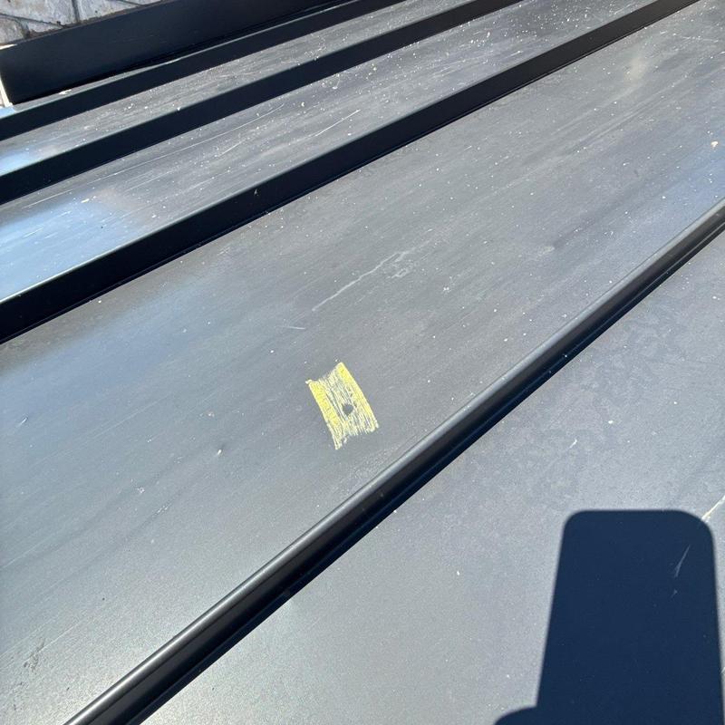 Metal roofing panel with hail damage marked