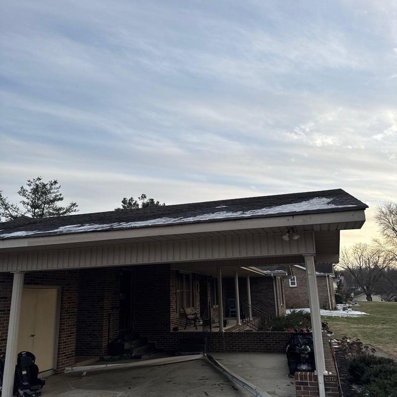 Asphalt shingle roof with hail damage and snow patches