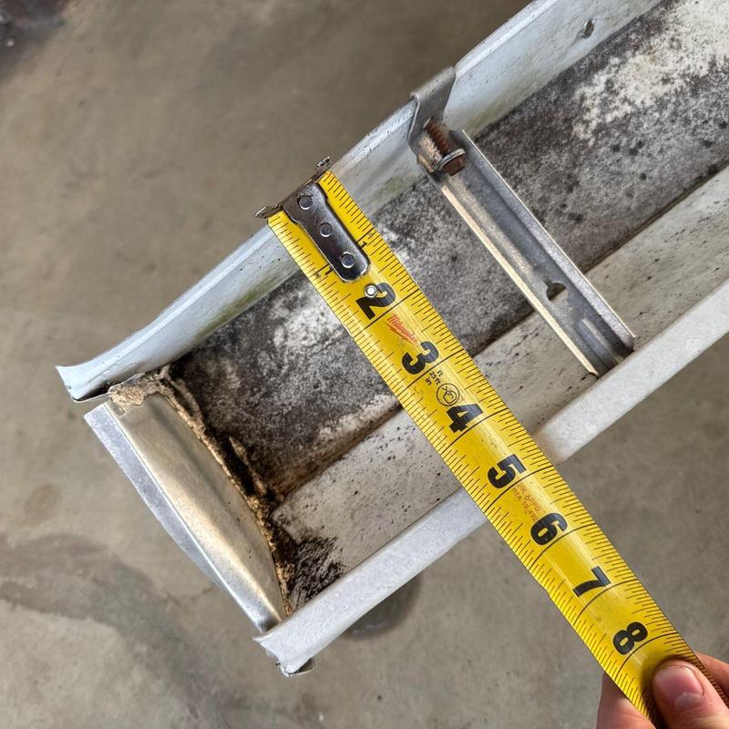 Metal roof gutter measuring with tape measure