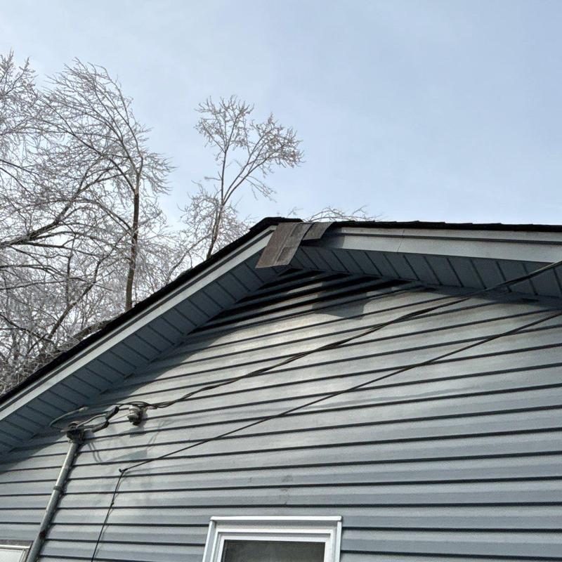 Roof edge and soffit with damaged shingles and trim