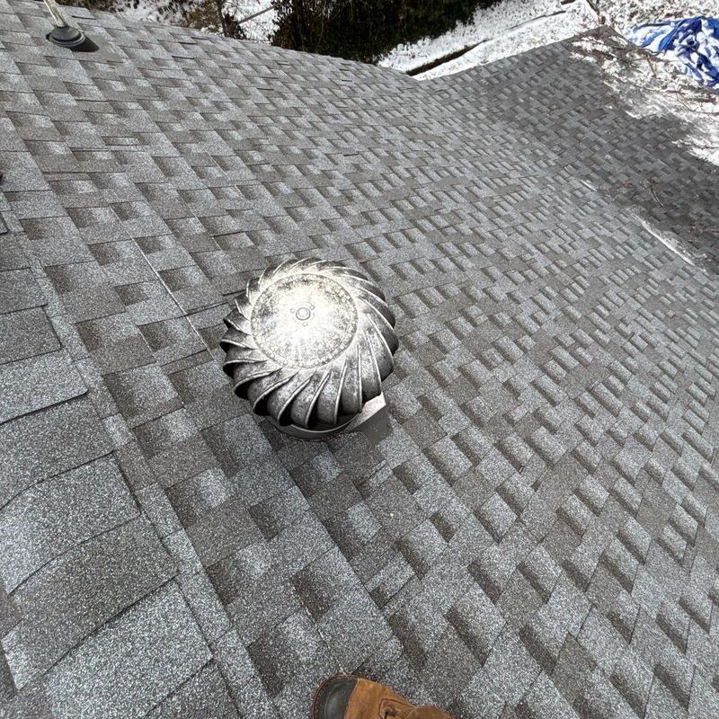 Roof shingles with hail damage and attic vent turbine