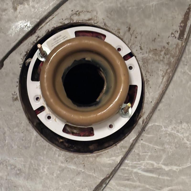 Toilet flange and wax ring with bolts on bathroom floor