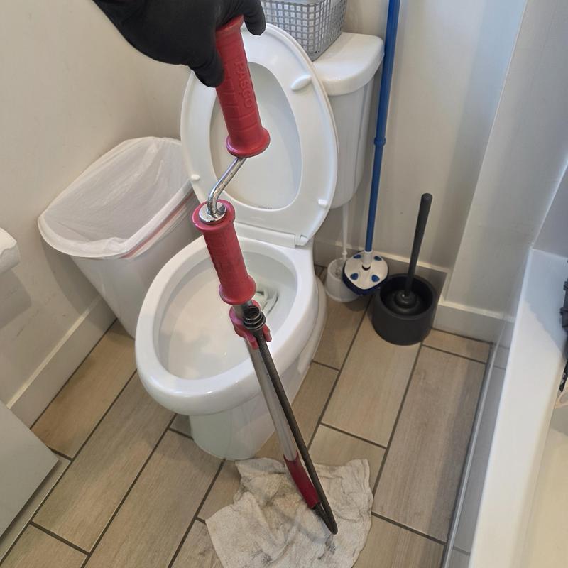 Toilet drain snake clearing blockage in bathroom restroom Toilet drain snake clearing blockage in bathroom restroom