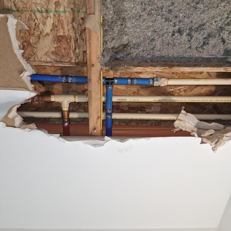Ceiling plumbing pipes with repaired leak access panel