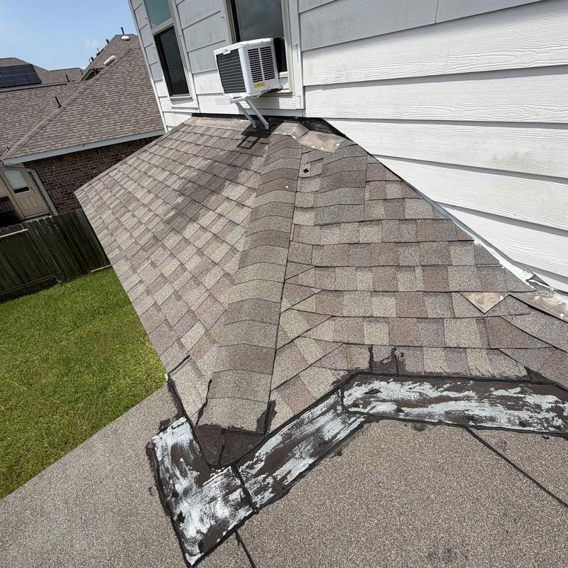 Asphalt shingle roof with patched leaks near wall-mounted AC unit