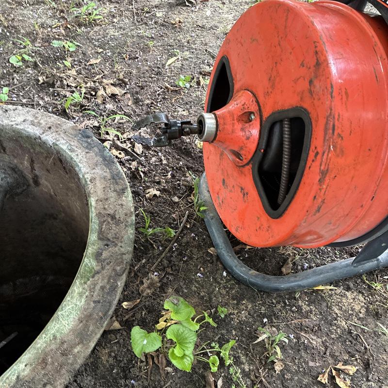 Sewer drain cleaning machine near pipe opening Sewer drain cleaning machine near pipe opening