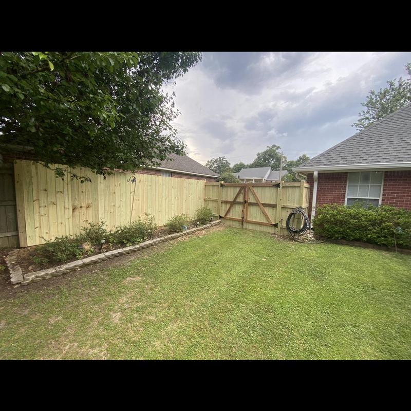 Wooden privacy fence with gate in backyard