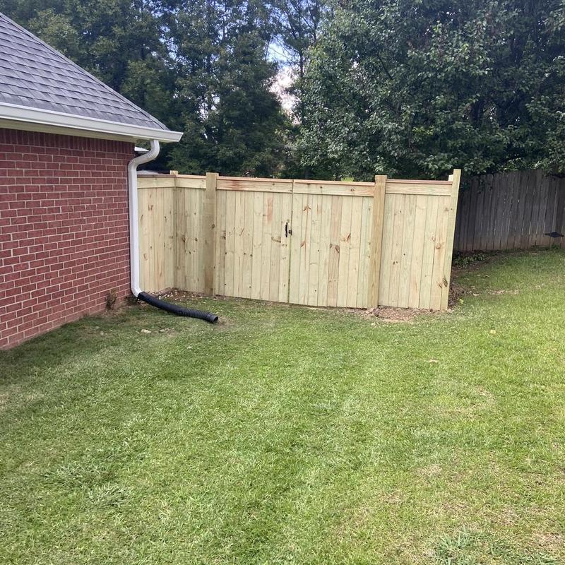 Privacy wood fence with gate in backyard corner