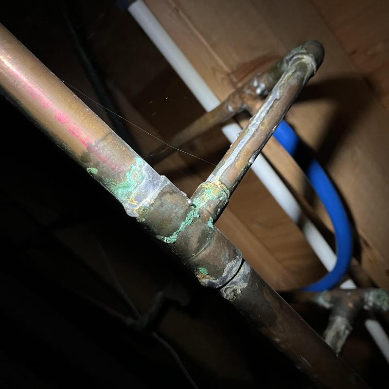 Corroded copper plumbing pipes with visible corrosion buildup Corroded copper plumbing pipes with visible corrosion buildup