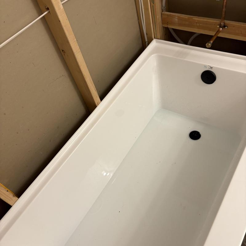 Acrylic bathtub installation in unfinished bathroom framing
