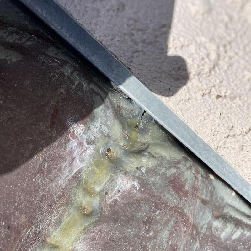 Tile roof flashing with sealant near stucco wall Tile roof flashing with sealant near stucco wall