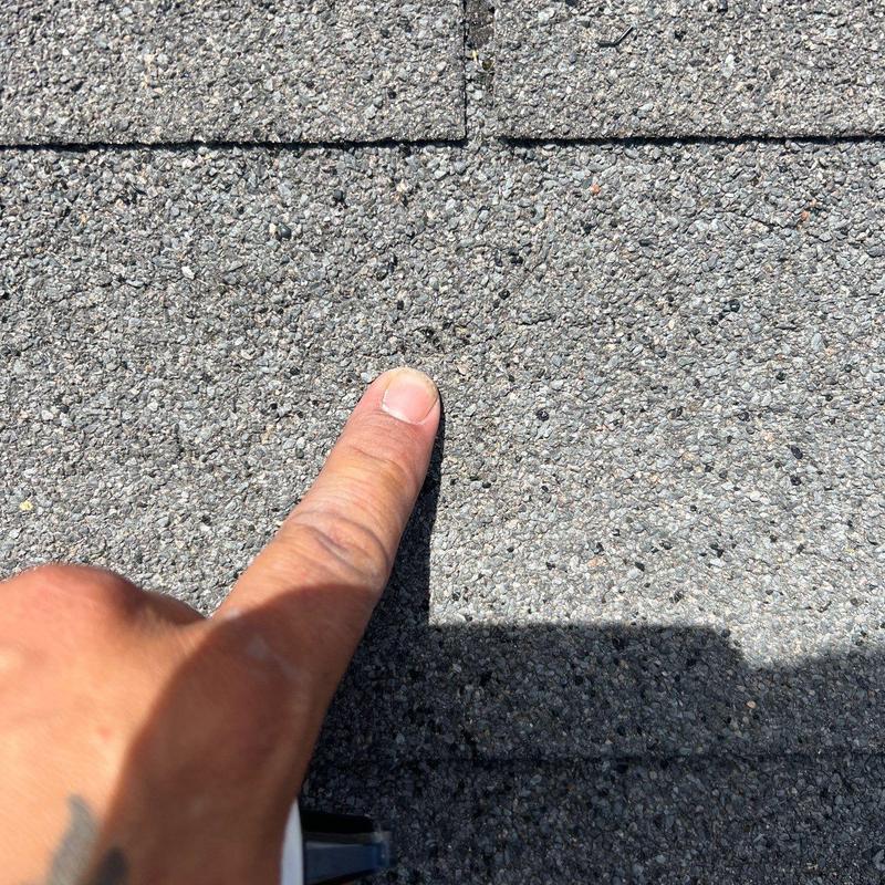 Asphalt shingle roof with hail damage spot