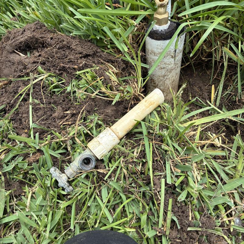 Outdoor hose bib and broken water pipe in grass Outdoor hose bib and broken water pipe in grass
