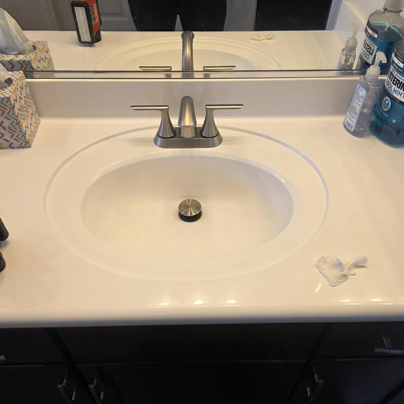 Four-inch lavatory faucet on white bathroom sink Four-inch lavatory faucet on white bathroom sink