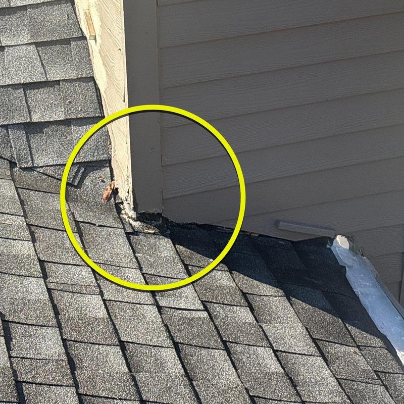 Roof shingles near siding with hail damage and cracks