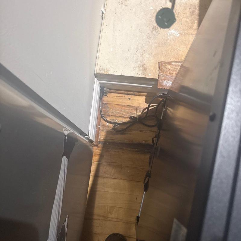 Flooring damage and baseboard near kitchen appliances
