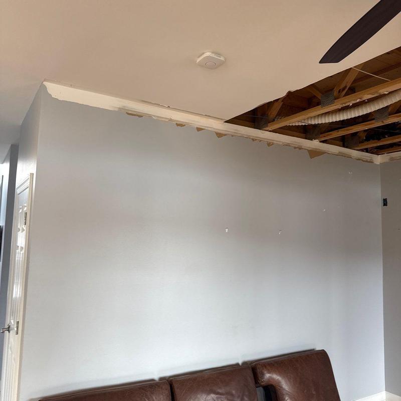 Ceiling drywall removal exposing wooden beams and pipes