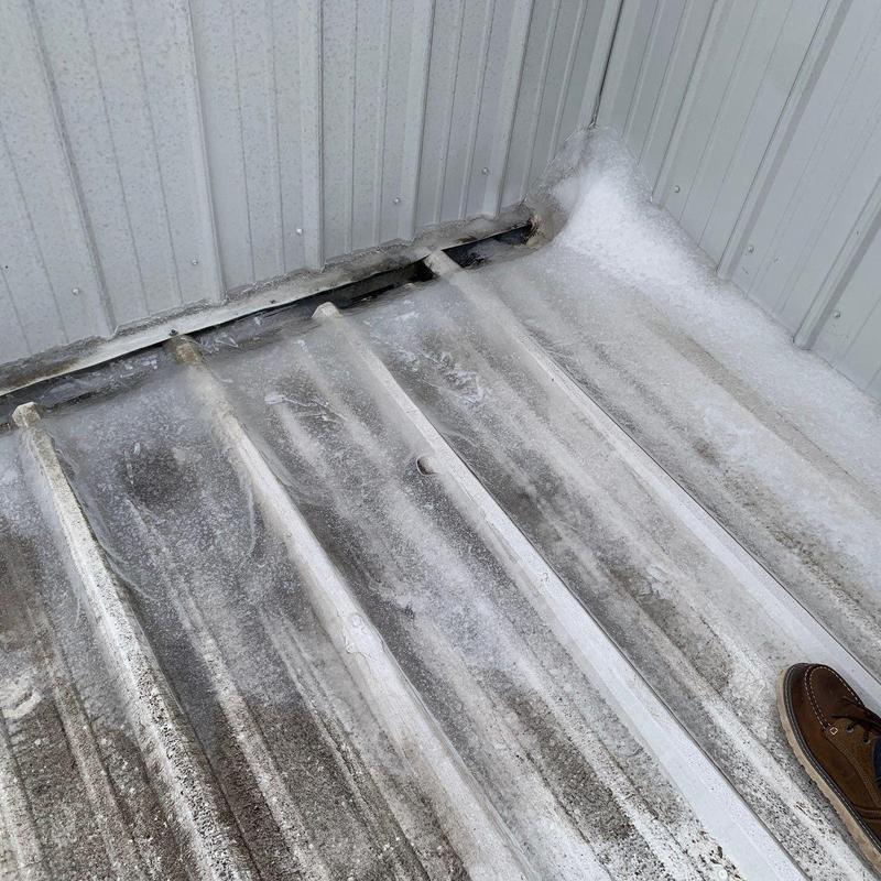 Metal roof panel with hail damage near flashing