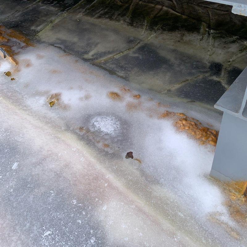 Commercial roof membrane with hail damage and rust stains
