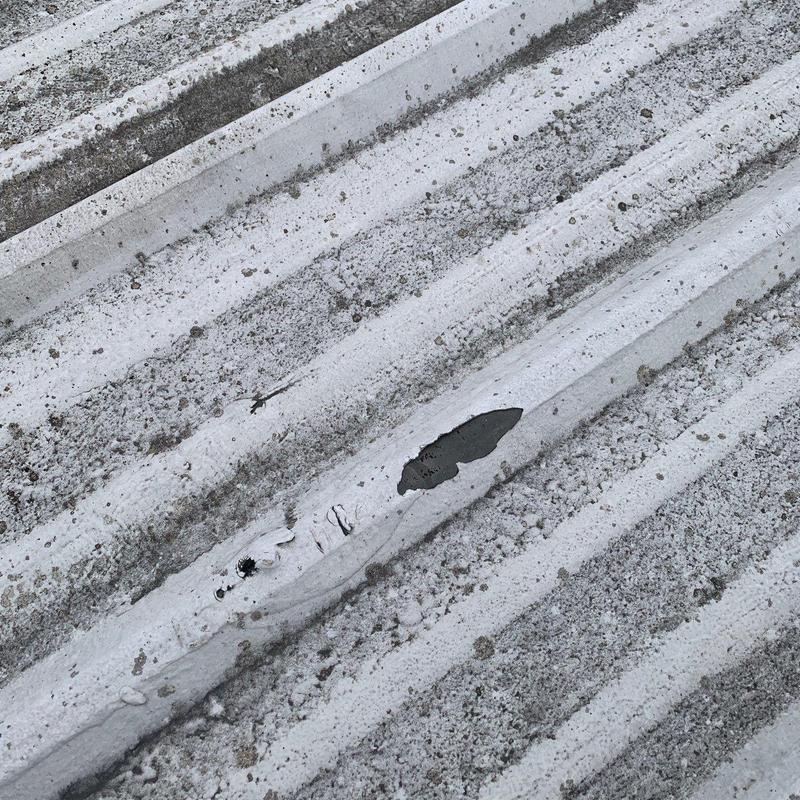 Metal roofing panel with hail damage hole