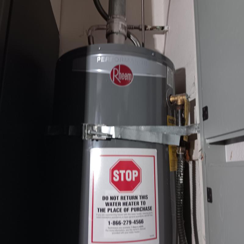 Water heater unit with warning label near electrical panel
