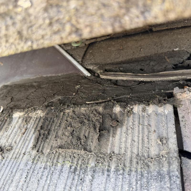 Tile roof valley debris buildup and condition inspection