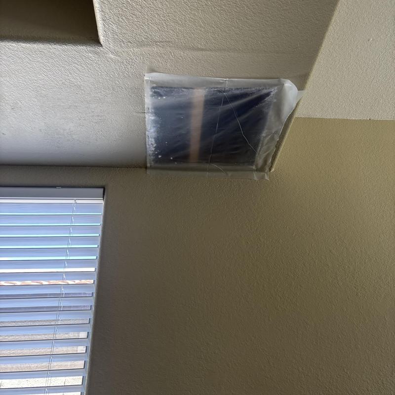 Drywall access hole covered with plastic sheet