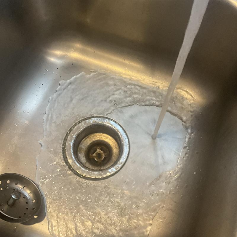 Kitchen sink drain with running water clearing blockage