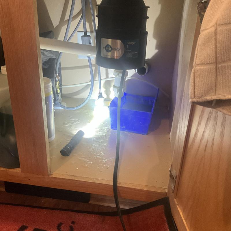 Garbage disposal installation under kitchen sink cabinet