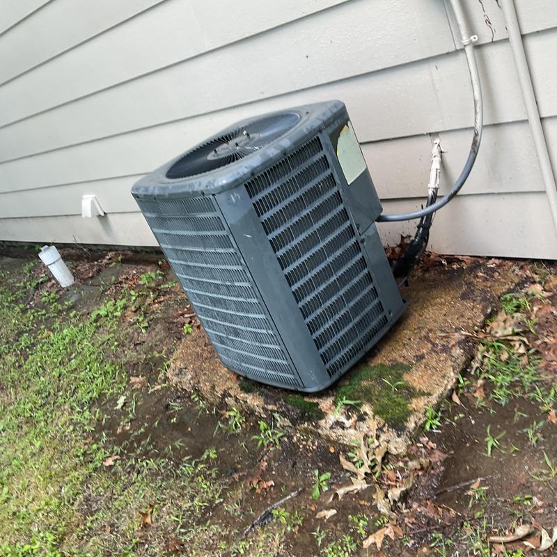 Air conditioner condenser unit on concrete pad outdoors